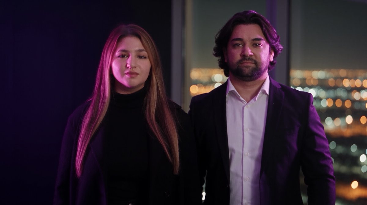 Lina Nase und Tobias Nase in einem Büro mit Blick über die Stadt